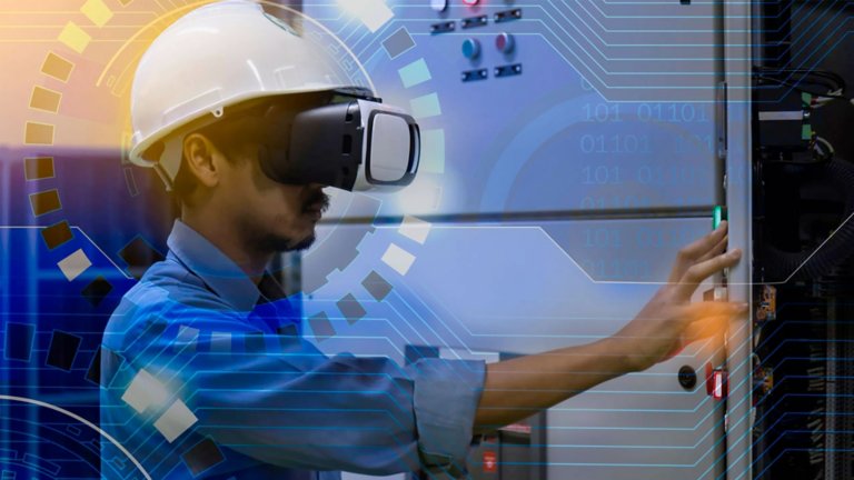 Funcionário em uma fábrica usando capacete de realidade virtual e parado na frente de um componente