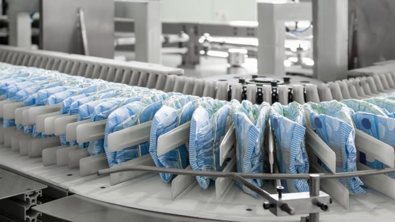 diapers on a conveyor belt closeup. factory and equipment for the production of pampers 