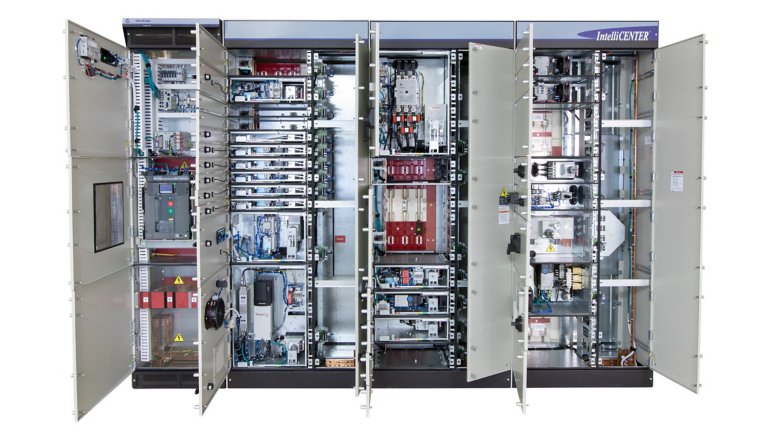 A large gray metal CENTERLINE 2500 motor control center with four tall vertical doors open showing multiple VFDs, motor starters, electronic devices and safety components. motor control center with  doors open show multiple VFDs, motor starters and safety components