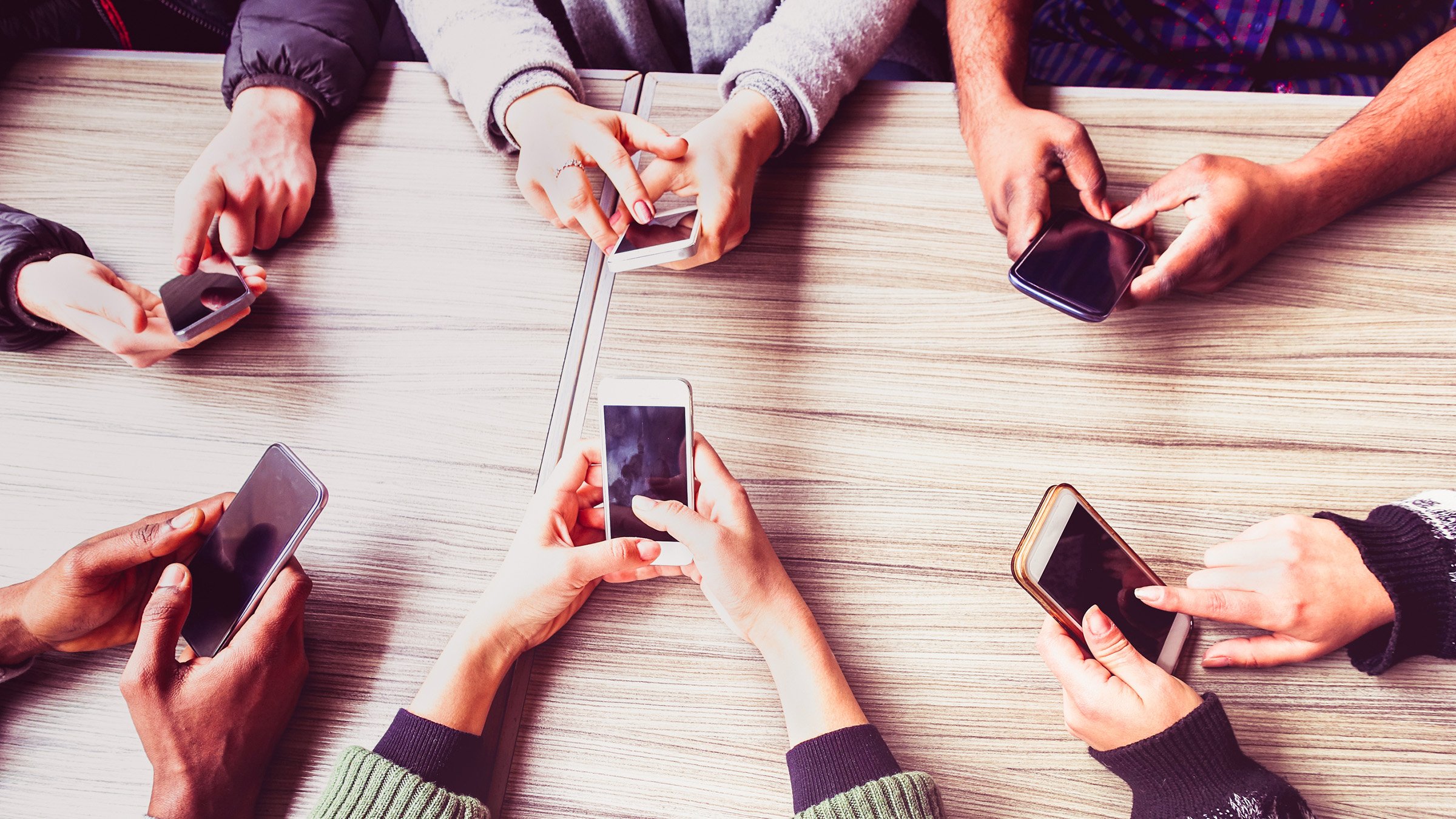 Coworkers with mobile phones at table in business meeting