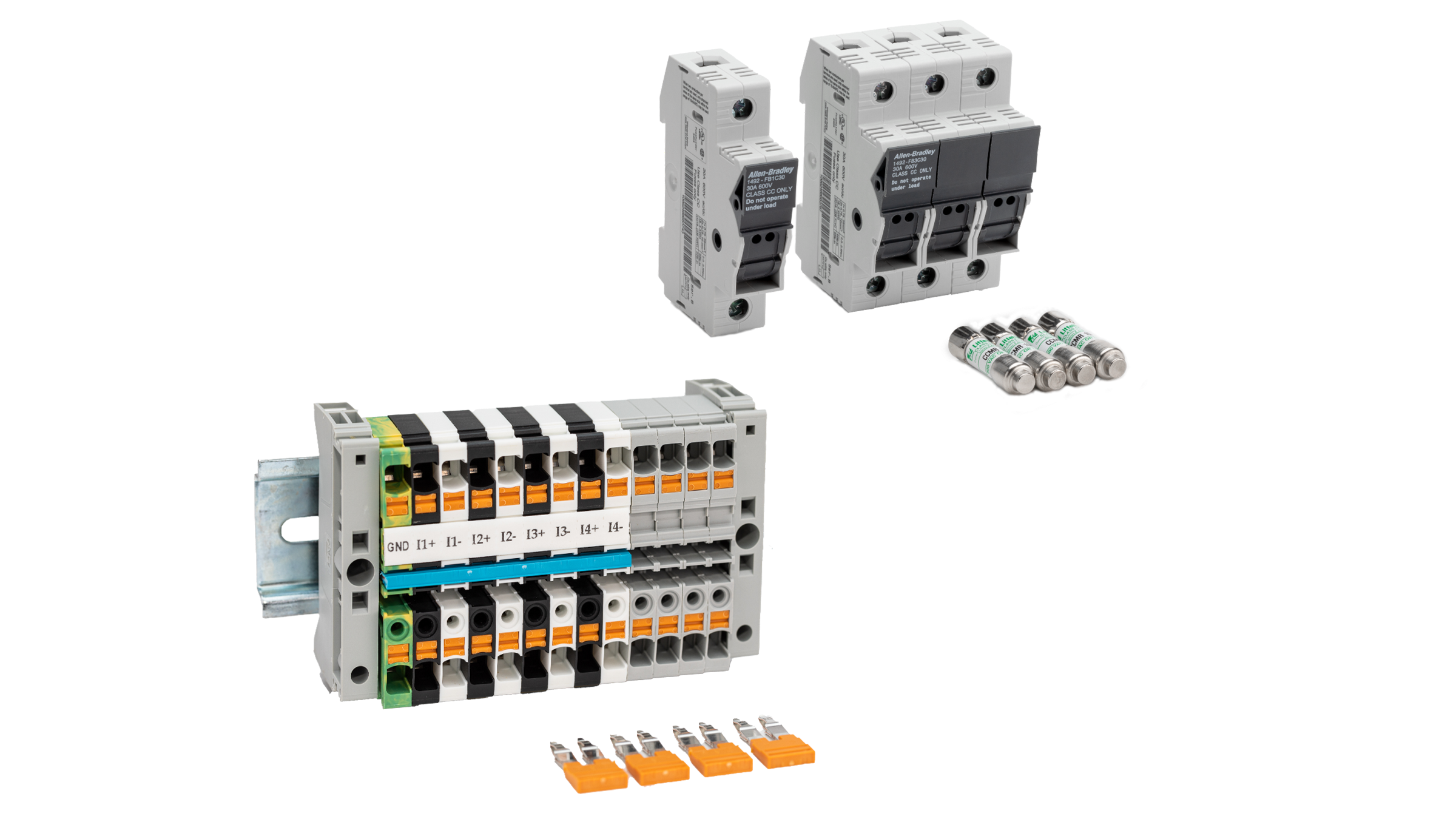 Group photo of PowerMonitor accessory kit with a single shorting block and four orange jumpers removed from block base in the foreground and one single 1 A fuse and three 10 A blocks with their matching fuses in the background