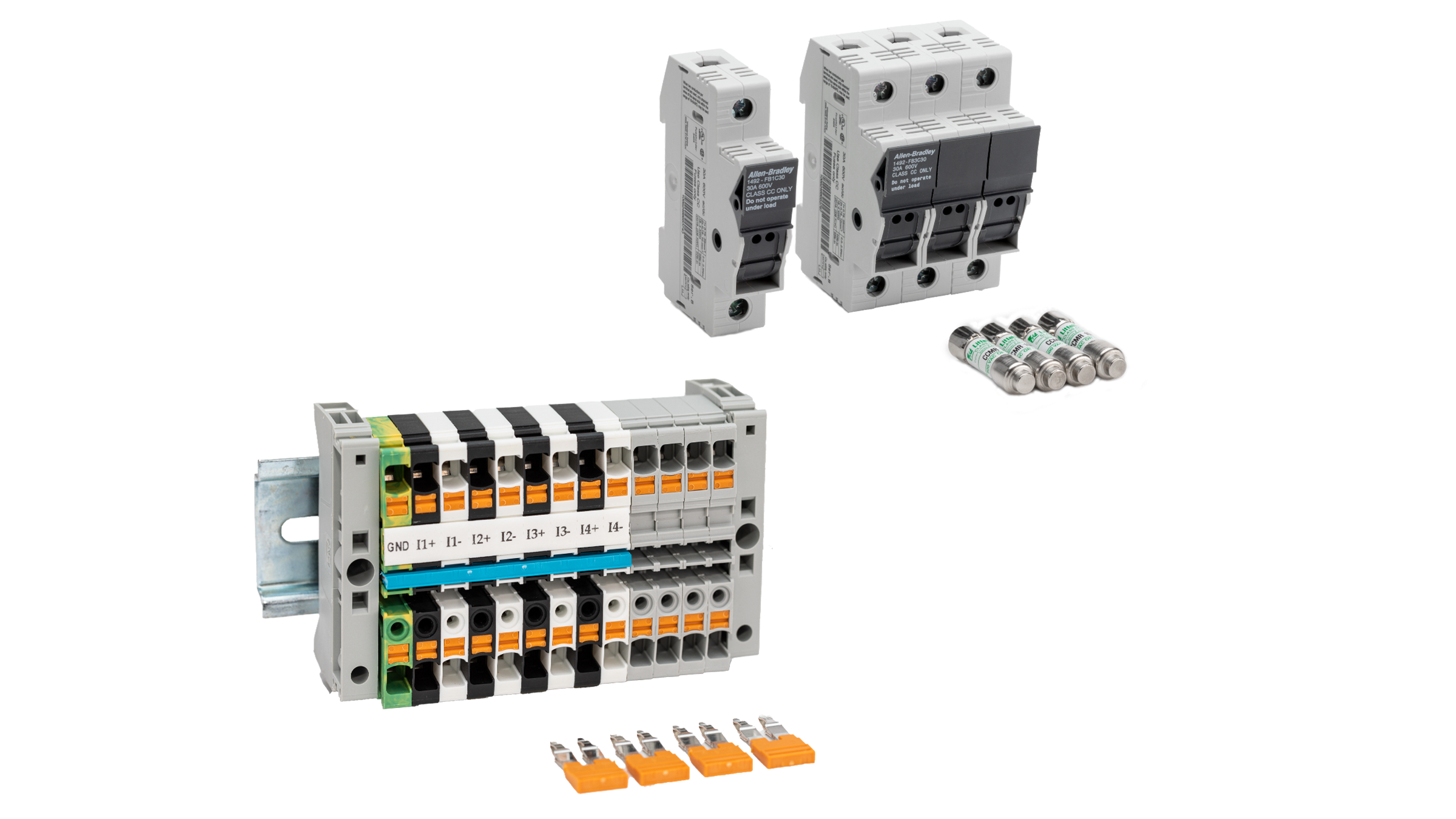 Foto de grupo do kit de acessórios PowerMonitor com um único bloco de curto-circuito e quatro jumpers laranjas removidos da base do bloco em primeiro plano e um único fusível de 1 A e três blocos de 10 A com seus fusíveis correspondentes ao fundo