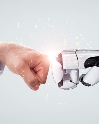  AI robot arm fist bumping male arm in gray business suit representing the collaboration of man and computer