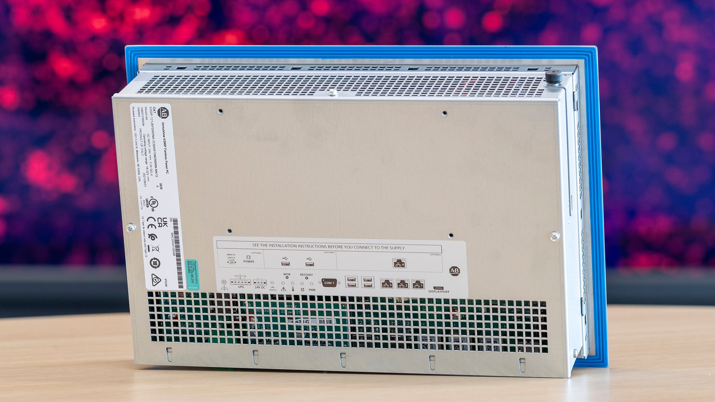 Rückansicht des ASEM-6300P-Panel-PCs aus Edelstahl. Hintergrund ist rot und schwarz