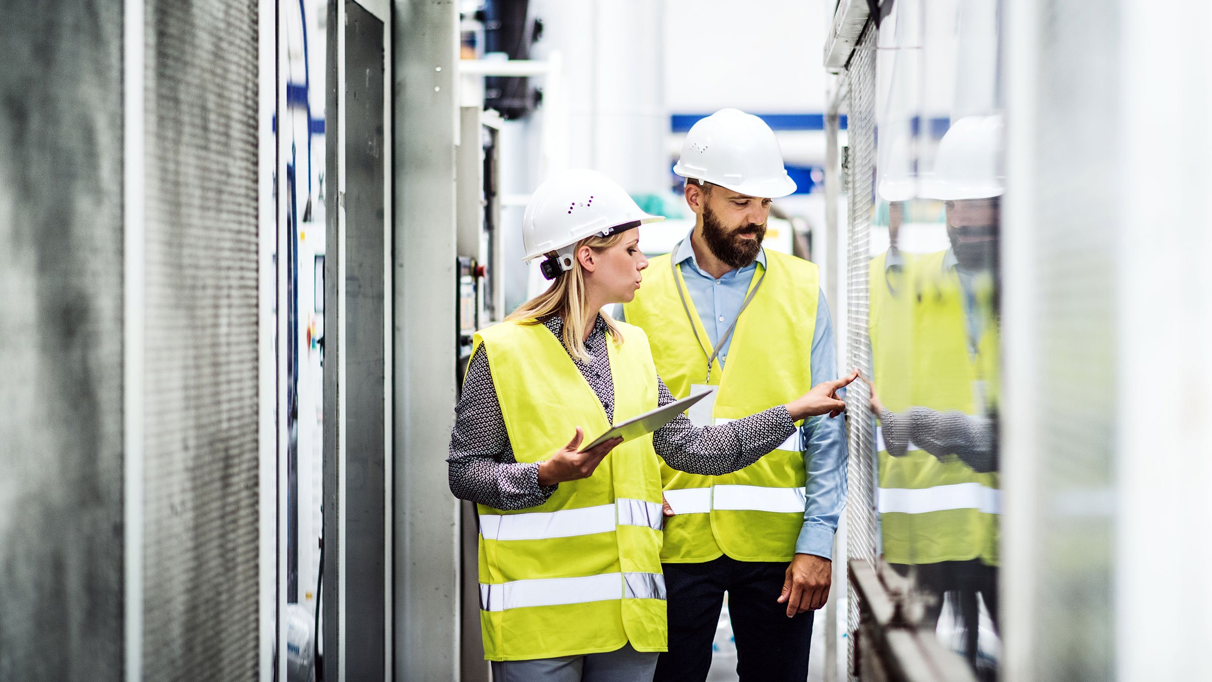 A man and women are monitoring a process line of factory.