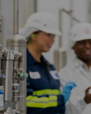 Workers in cheese factory consult on automation lifecycle services