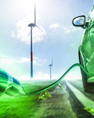 Green electric vehicle driving down road with the vehicle charging cable trailing behind