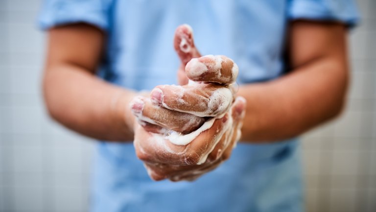 Mann in medizinischer Kleidung wäscht seine Hände