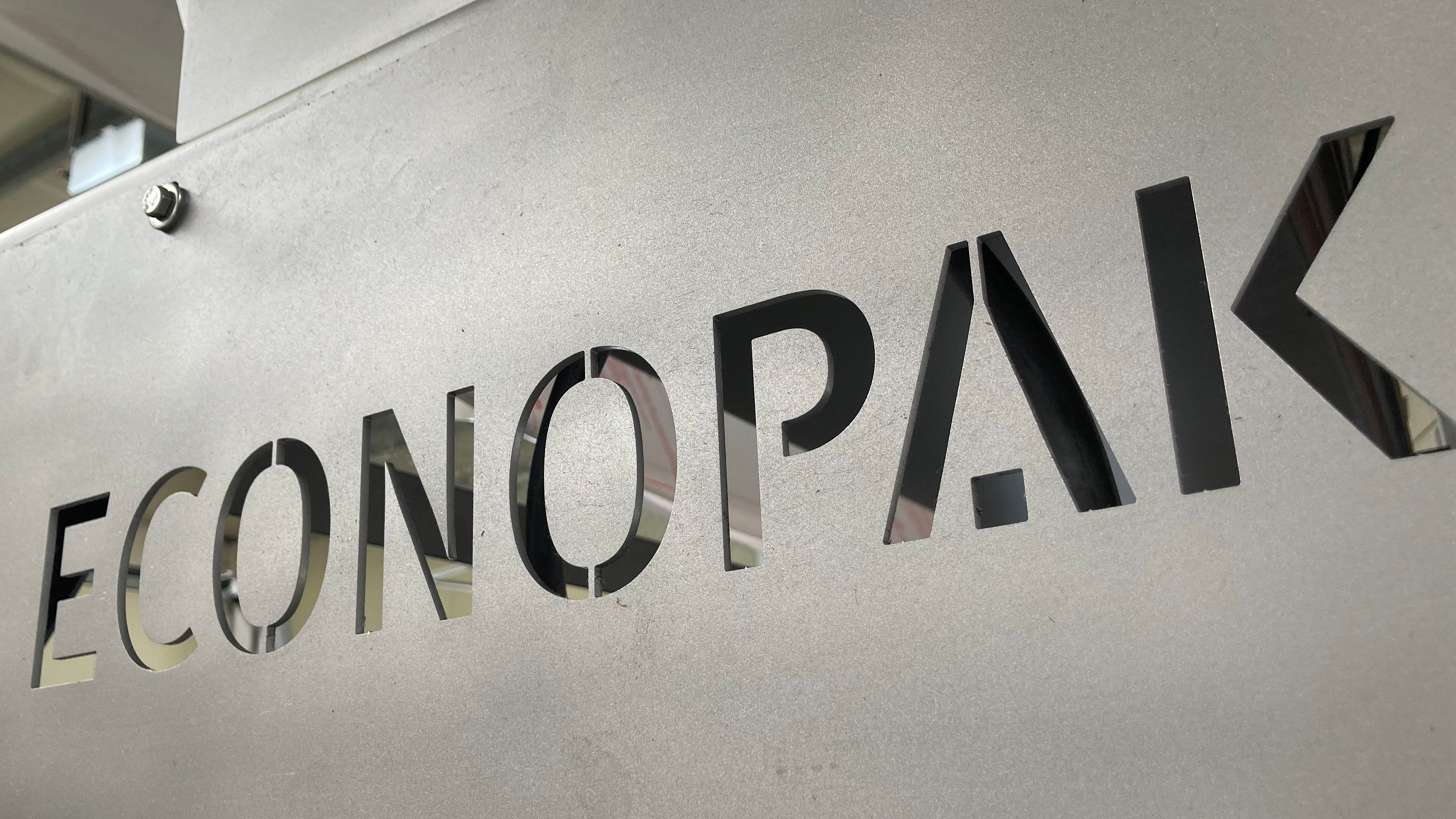 Ekonopak logo carved on grey wall in production hall