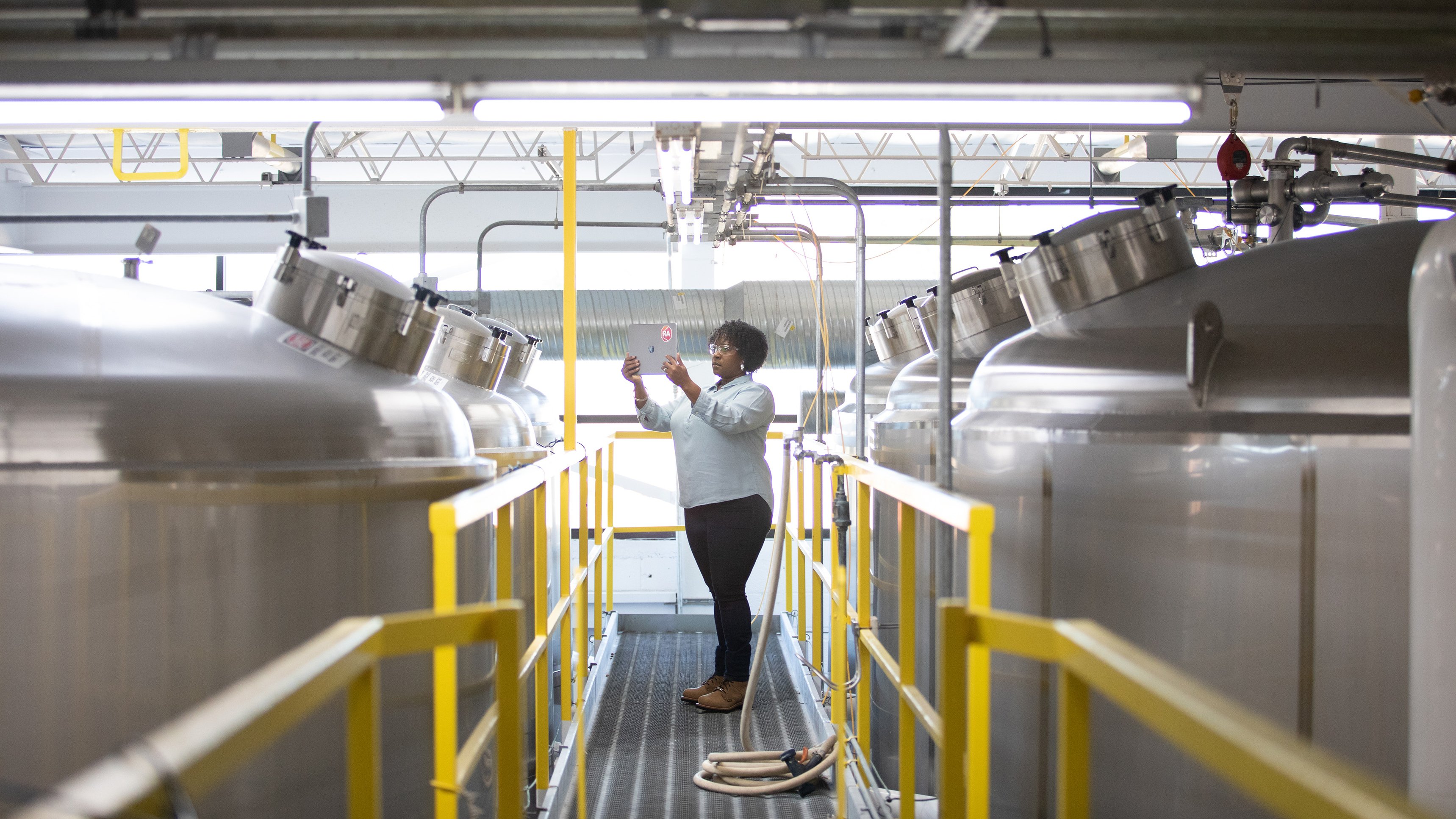 Woman in Automation reviewing content on iPad in manufacturing setting