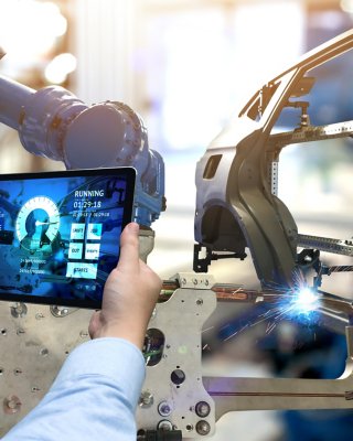Engineer hand using tablet with machine real time monitoring system software. Automation robot arm machine in smart factory automotive industrial Industry 4th iot , digital manufacturing operation.