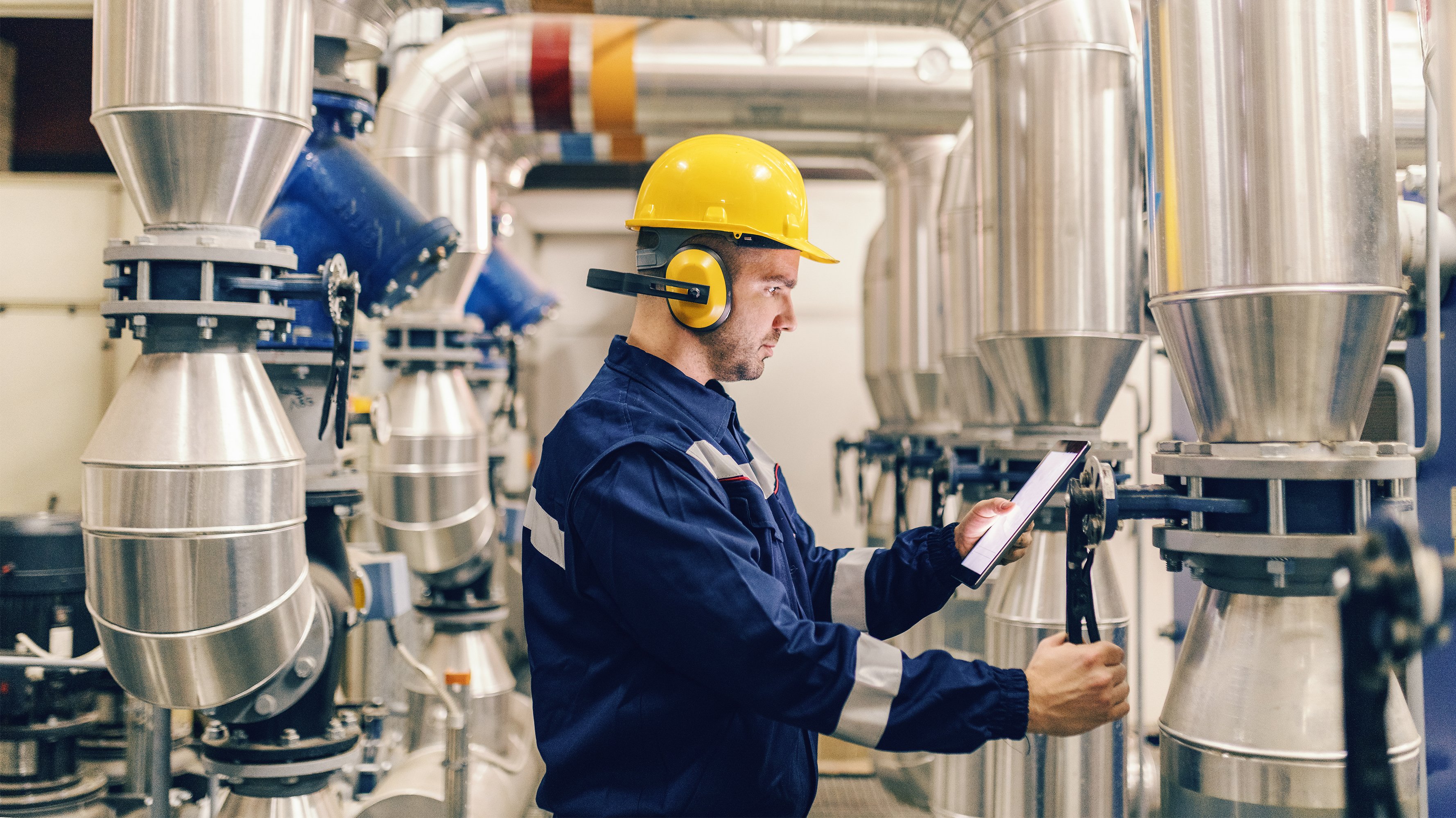 Maintenance male worker using tablet in heating plant