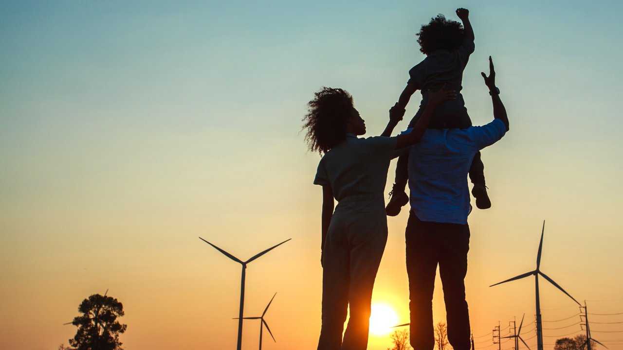 Silhouttes of a happy family with wind turbines