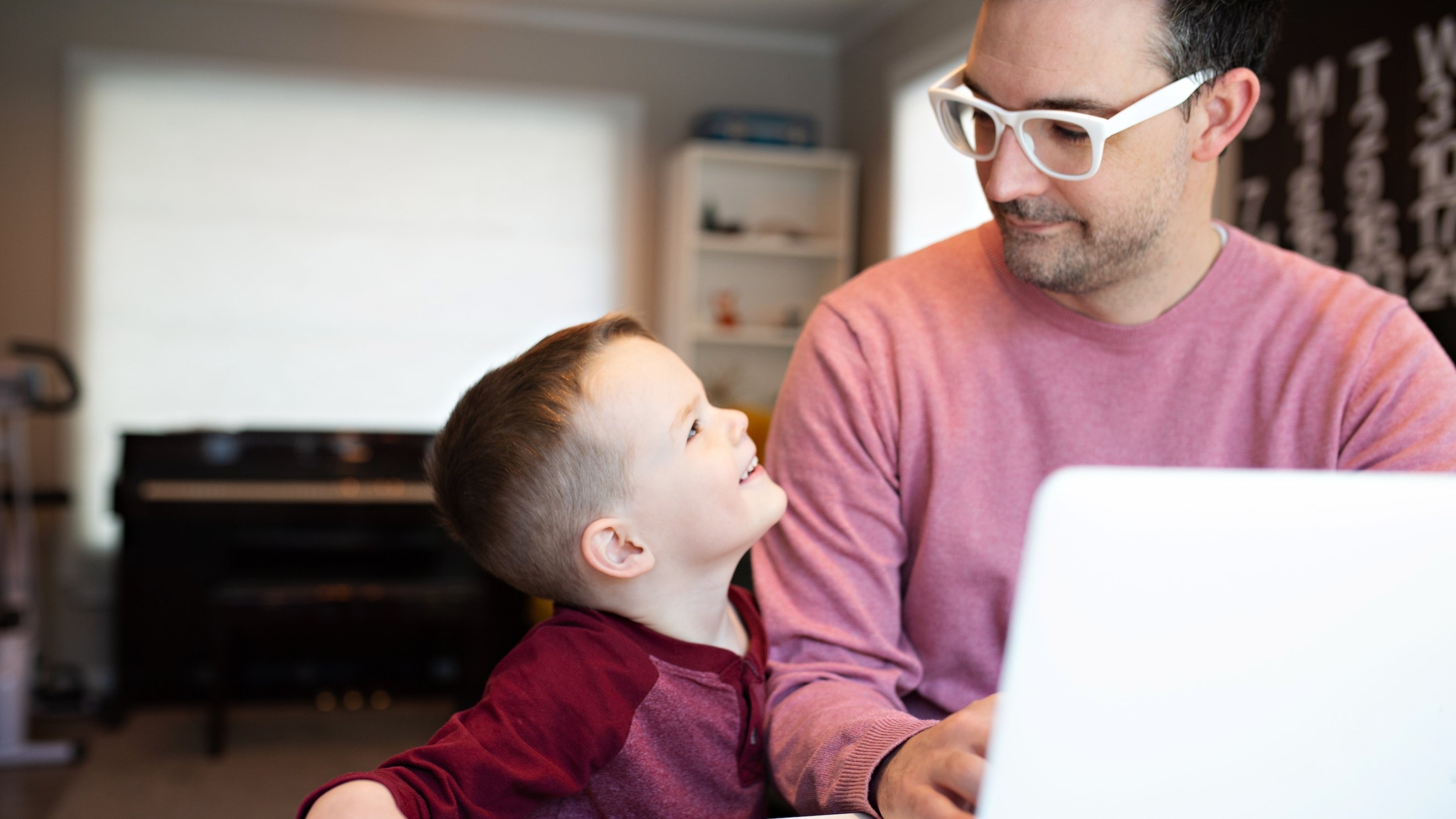 A father working from home is interrupted by his young son