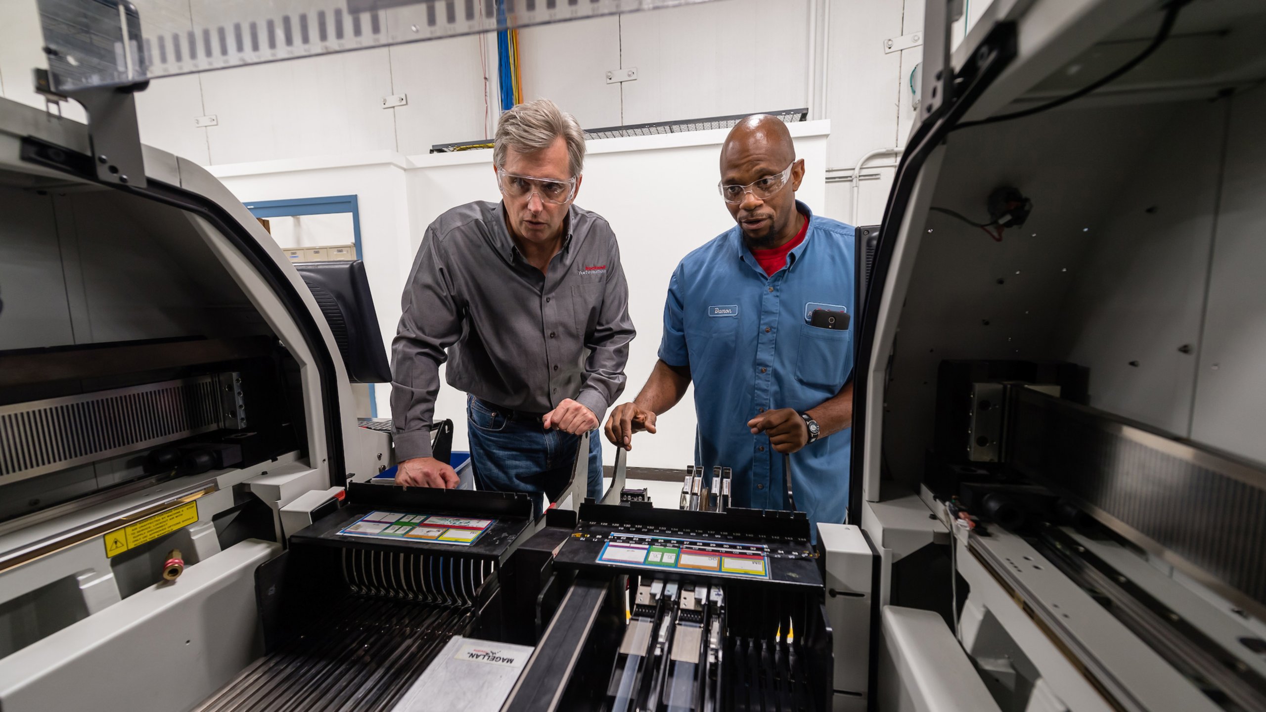 Dwóch pracowników Rockwell Automation w zakładach Twinsburg, Ohio, patrzy na pracującą maszynę