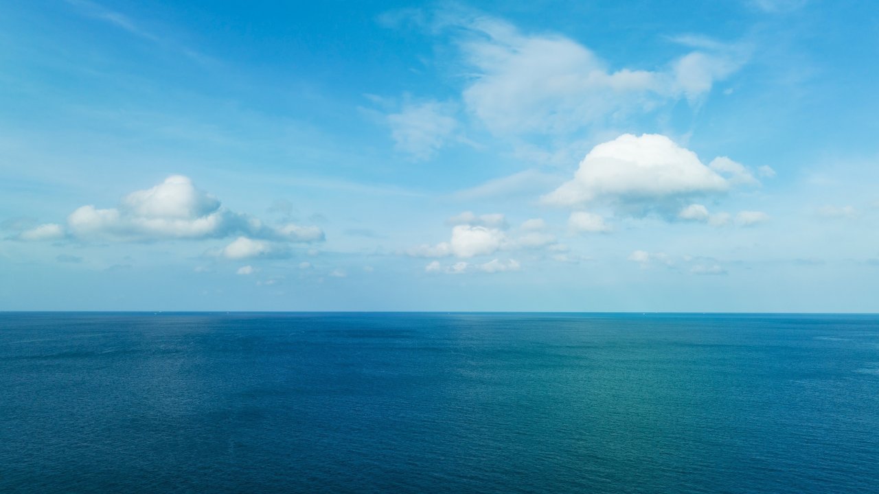 Aerial view of open ocean or sea and the blue sky in the brght light