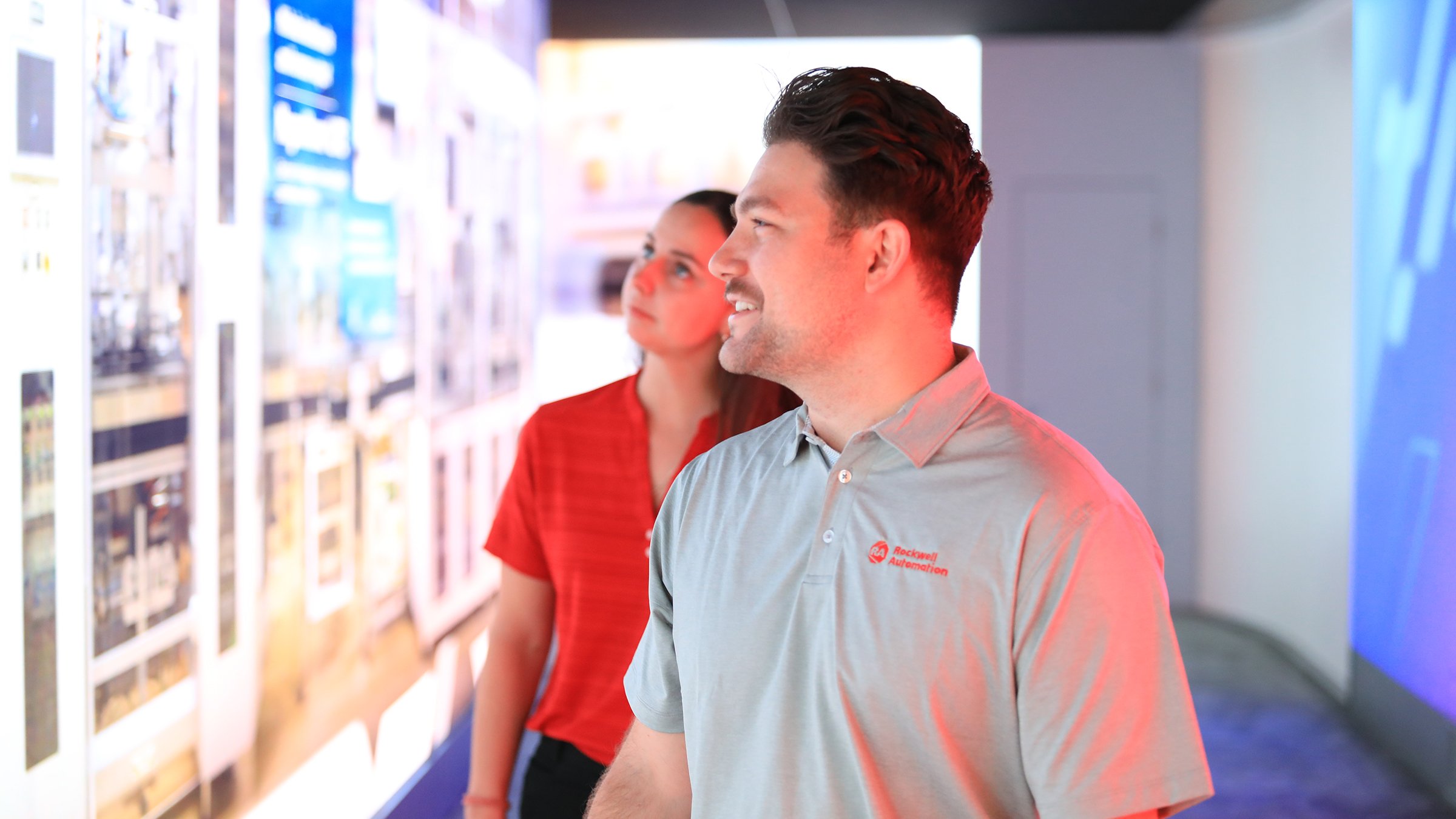 Two people looking at exhibit wall at Automation Fair 2021