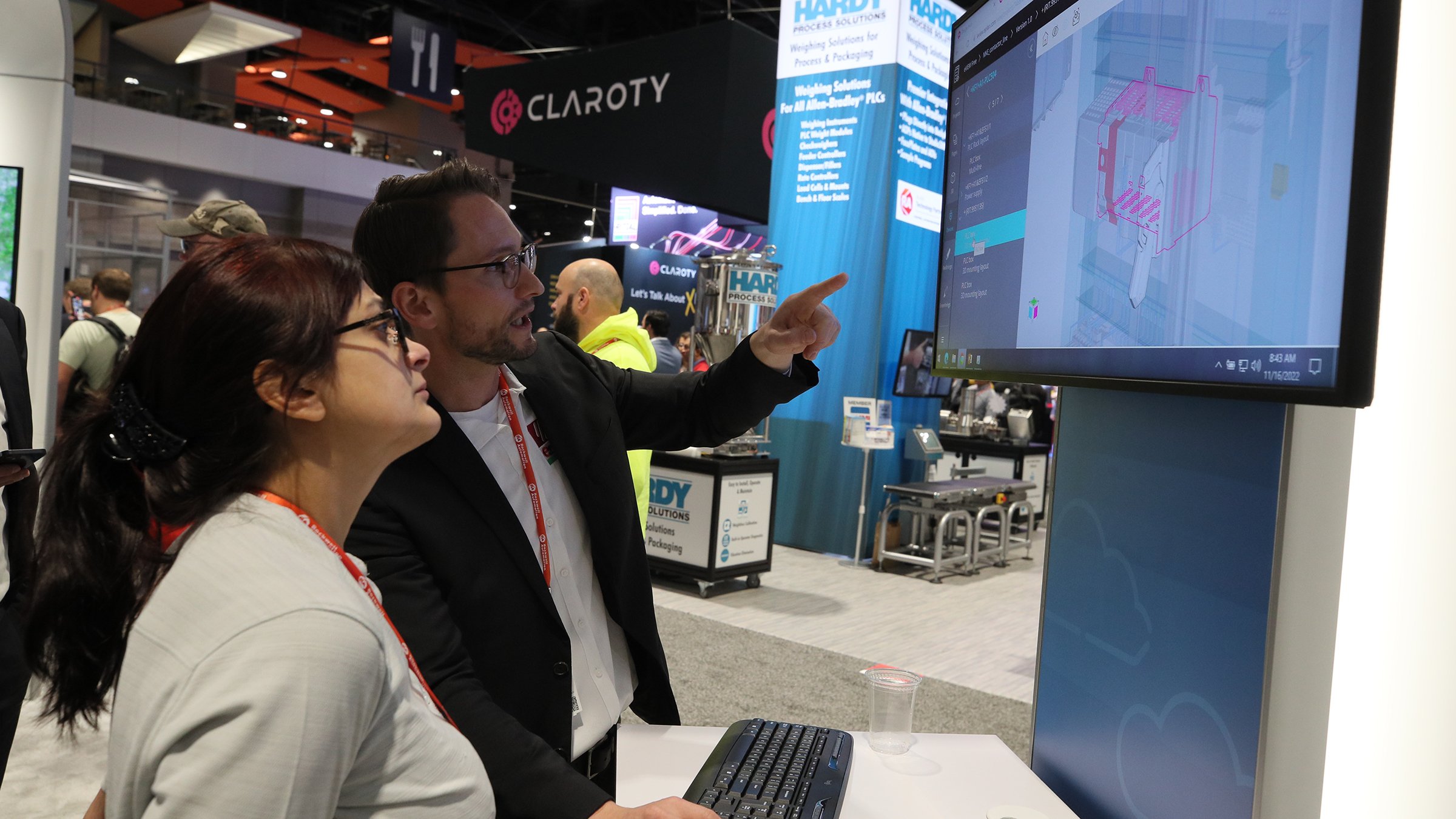Man and woman looking at monitor in a diplay on the show floor at Automation Fair 2022