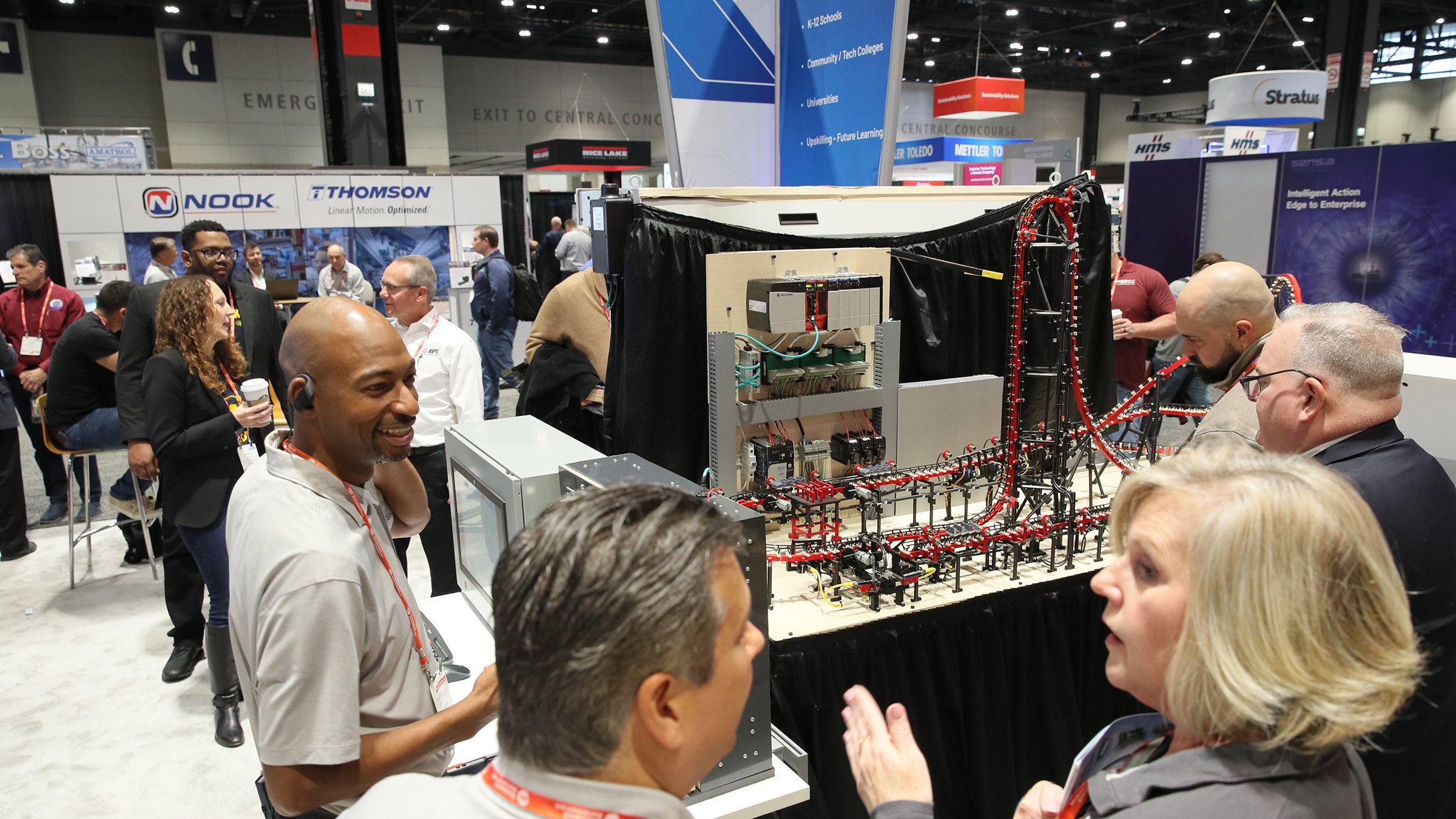 Group of people looing FIRST Robotics demonstration on show floor at Automation Fair 2022.