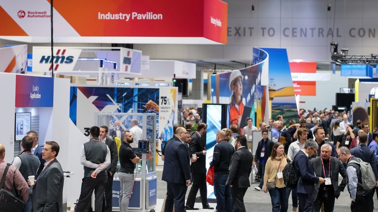 Attendees at Rockwell Automation Fair 2022 on the show floor looking at exhibitor booths and displays.