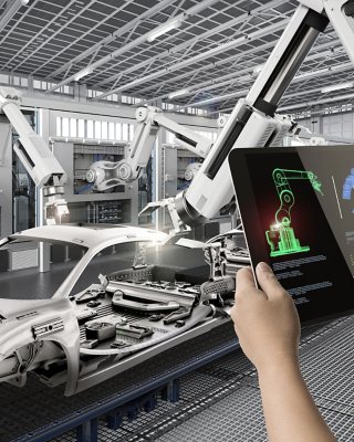 Person operating a robot in a car factory with a tablet