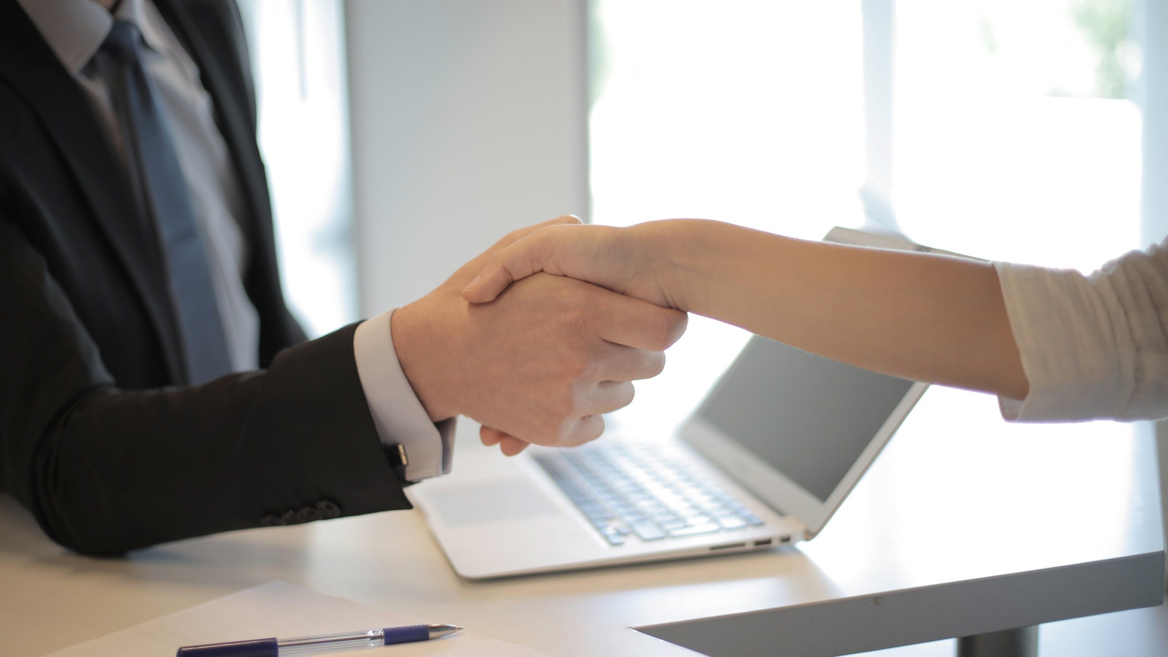 Person in Black Suit Hired An Employee, shaking hands.