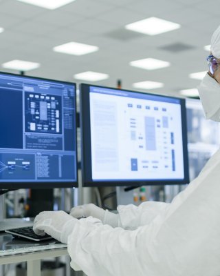 Personnel d’une usine pharmaceutique regardant des écrans de données