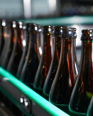 Brown glass bottles on filling manufacturing line beer factory, Trappist beer factory, bottle chain