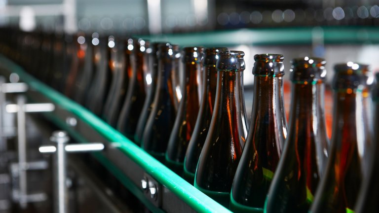 Brown glass bottles on filling manufacturing line beer factory, Trappist beer factory, bottle chain