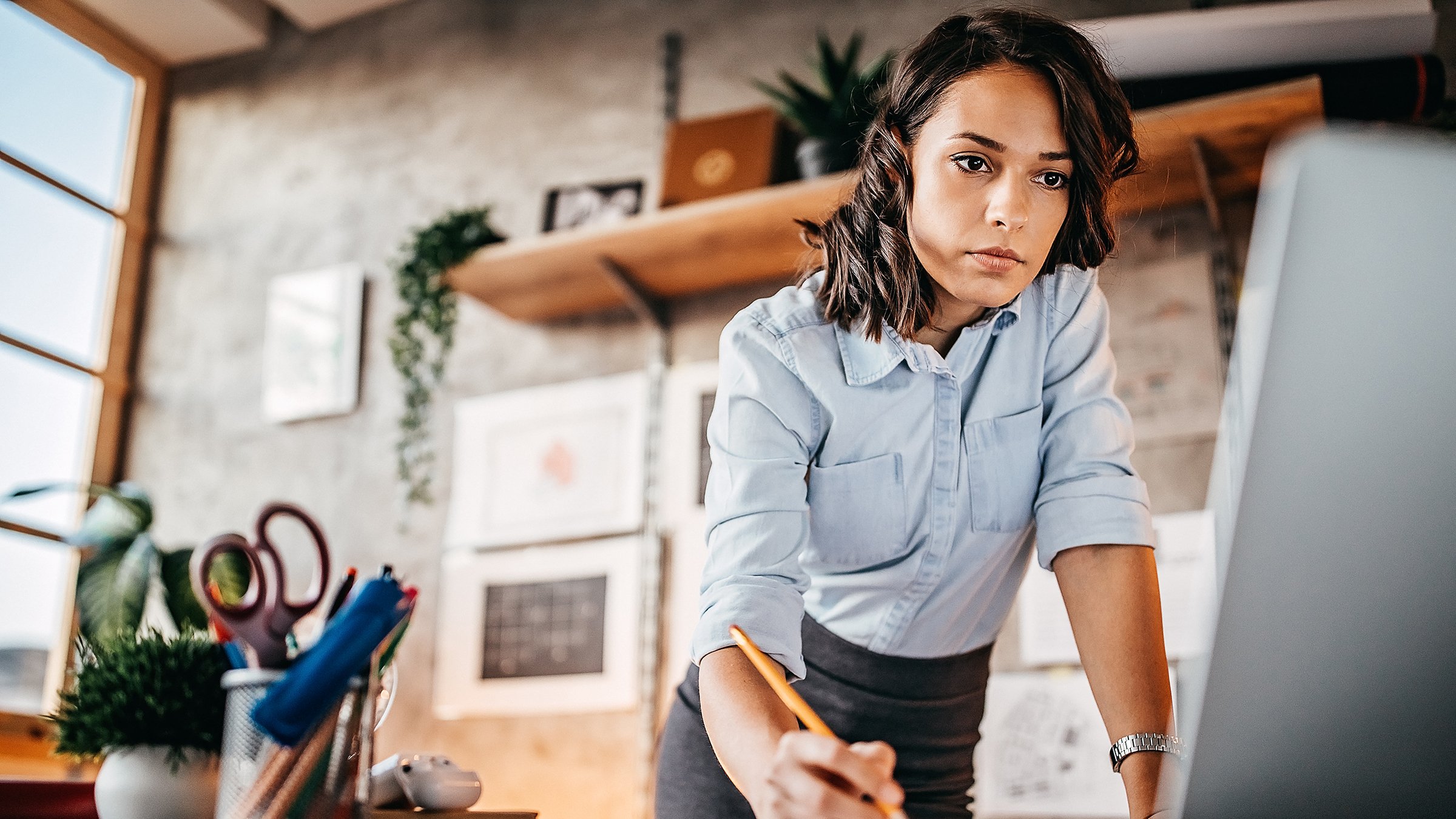 Businesswoman standing and using laptop at home office