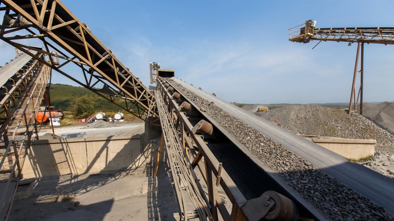 Crushed stone conveyor for dump trucks in a quarry