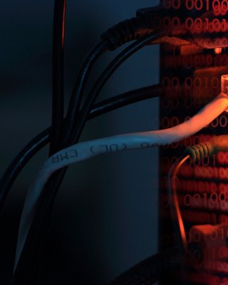 An internet LAN line connects to a computer with red binary code double exposed, to show security breaches and spyware