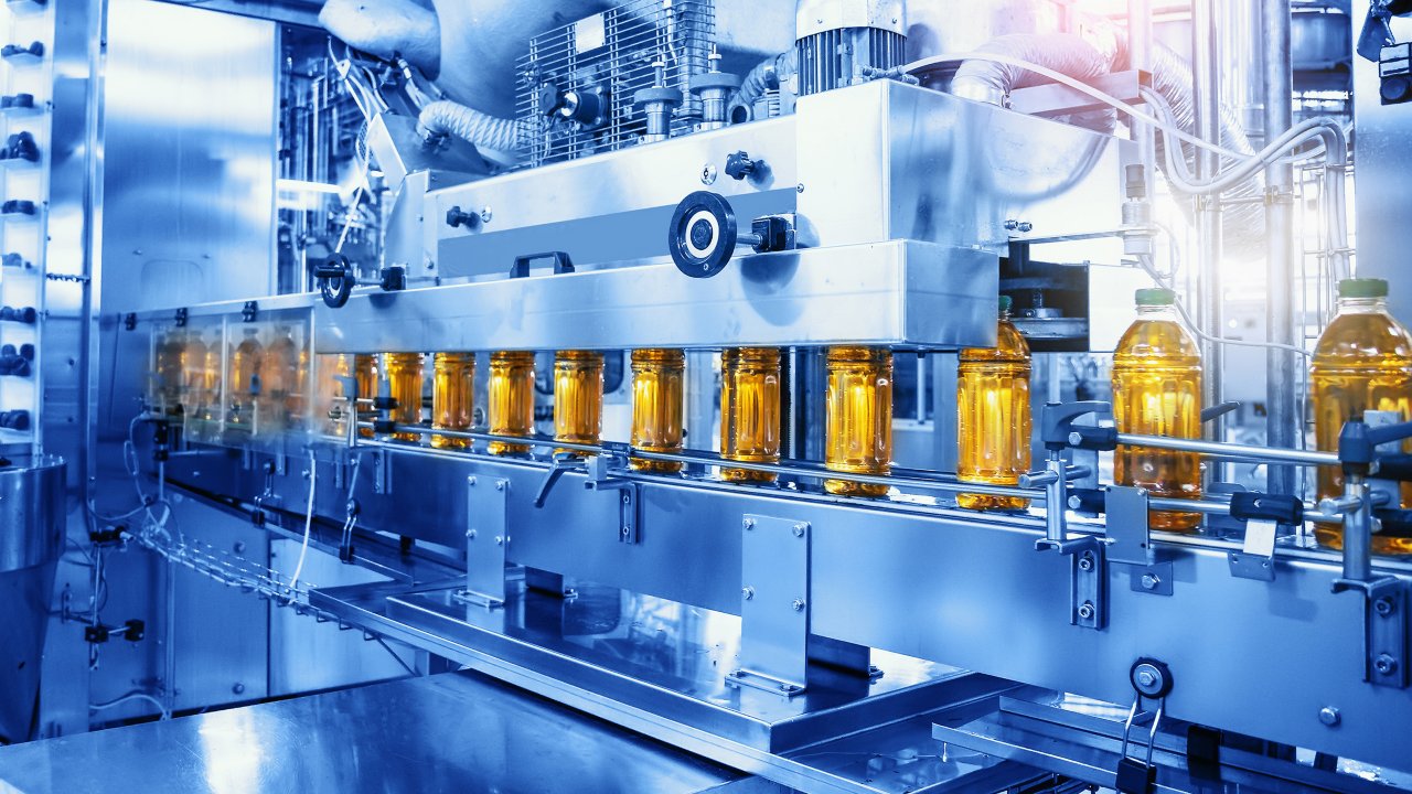 Conveyor belt with bottled yellow juice in a sterile food and beverage factory 