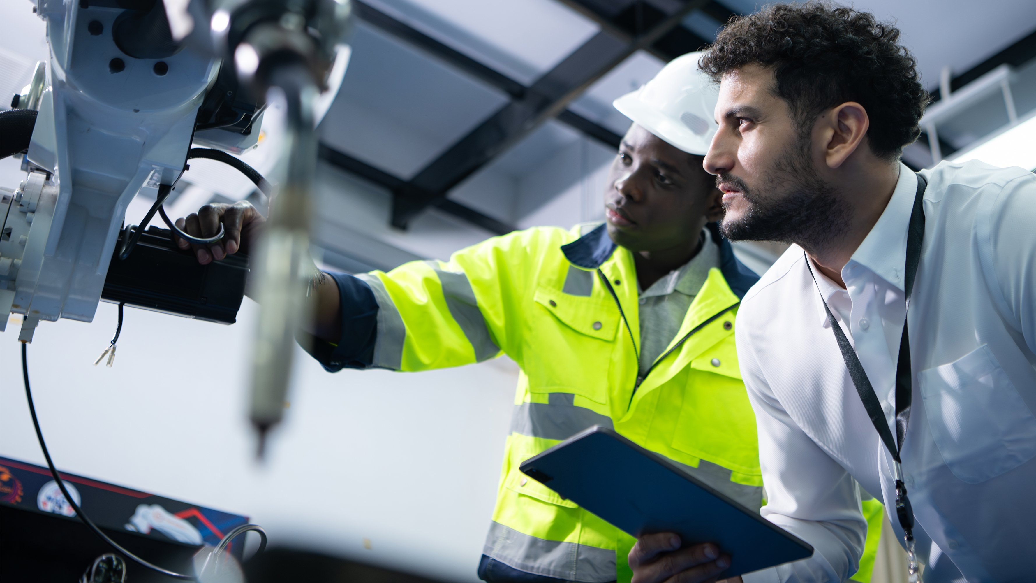 Technicians are introducing industrial hand robots to businessperson of factory industry who will use them in large-scale complex manufacturing operations.