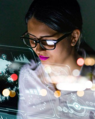 一位女工程师戴着眼镜在工作台前查看笔记本电脑上的软件界面