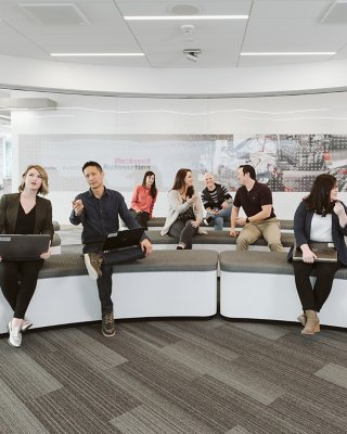 diverse group of young people sitting on couches in the Rockwell Automation Milwaukee Customer Center. Group of Rockwell employees during a presentation.