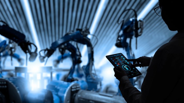 Engenheira industrial de fábrica trabalhando com braços robôs de automação em uma fábrica industrial inteligente em um software de sistema de monitoramento em tempo real. Manufatura digital do futuro.