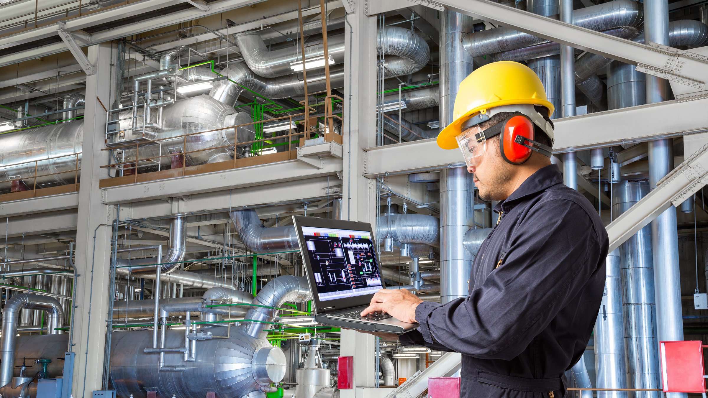 Engineer using laptop computer for maintenance equipment and pipeline system in thermal power plant factory