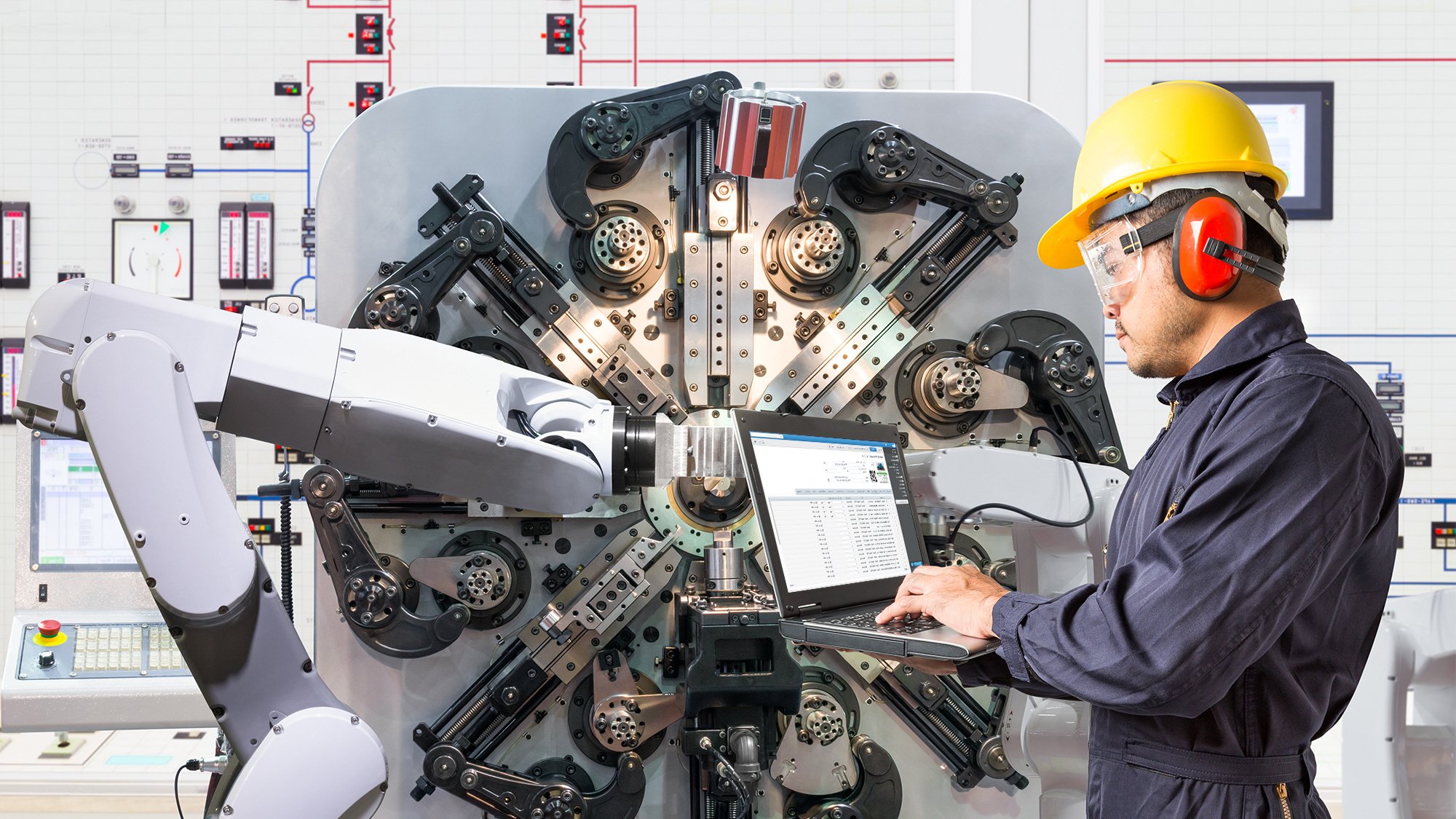 Ingeniero con computadora portátil operando máquina de mantenimiento