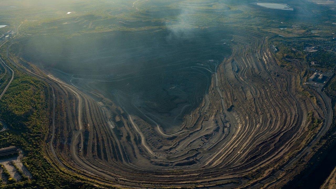 Open pit mining for steel production. A giant iron ore quarry. Aerial view of an open pit quarry