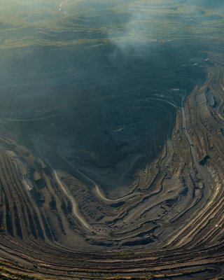Open pit mining for steel production. A giant iron ore quarry. Aerial view of an open pit quarry