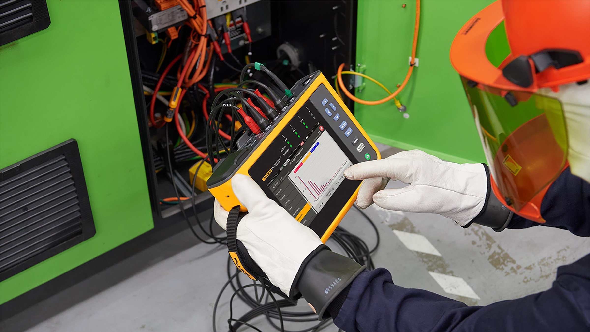 Maintenance worker using an electrical test tool and following electrical safe work practices.