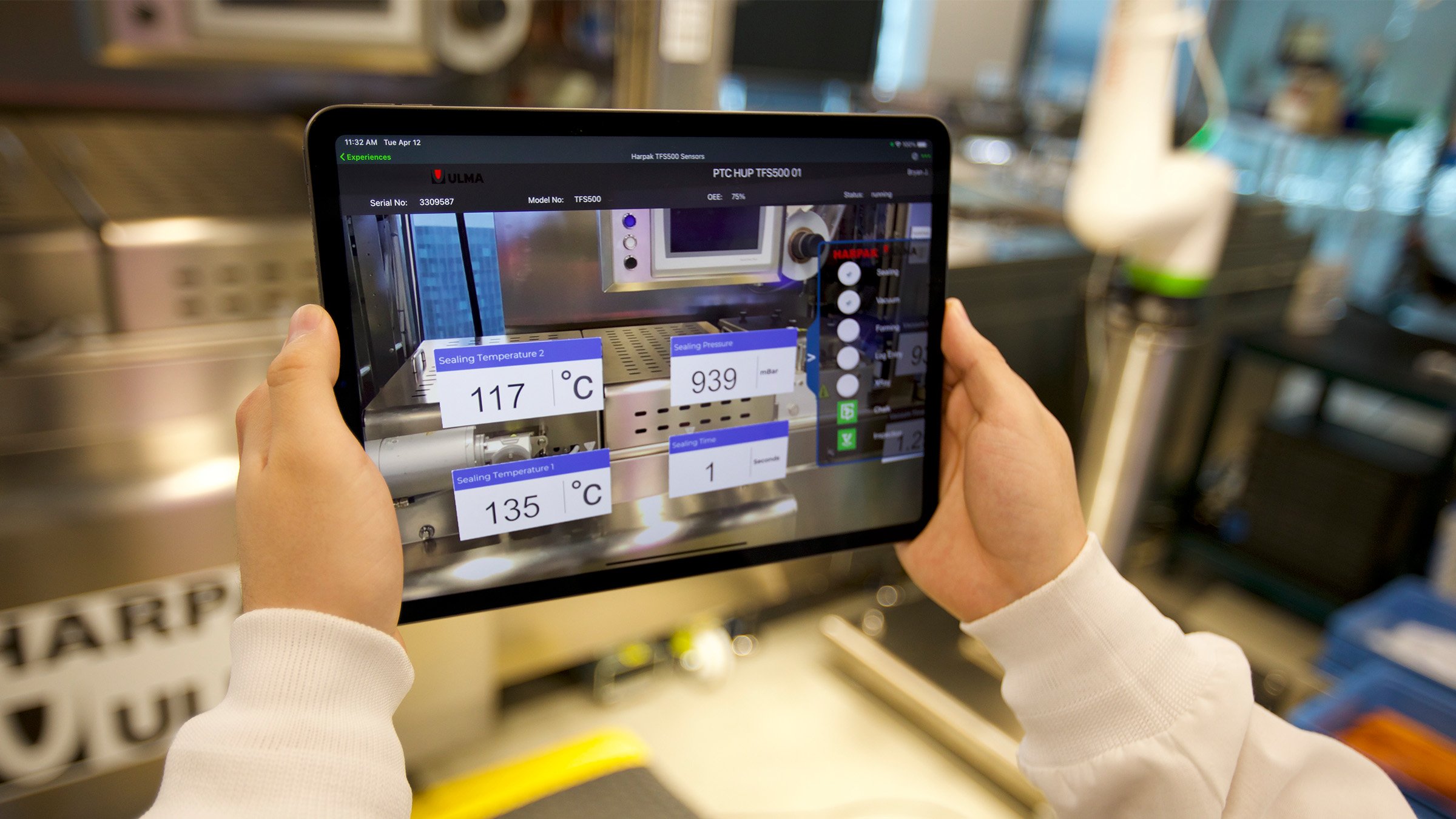 Hands holding tablet with PTC VR software images showing temperature and other information