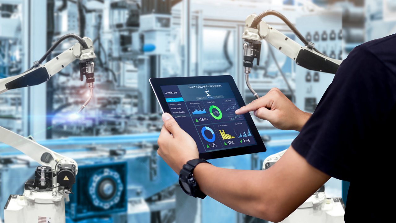An image of an engineer controlling automation machinery using a tablet.