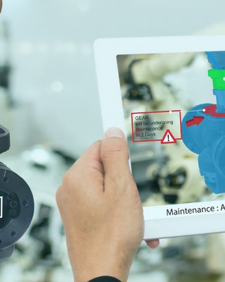 Hands holding a tablet using augmented reality to view instructions in a plant/factory. Digital transformation.
