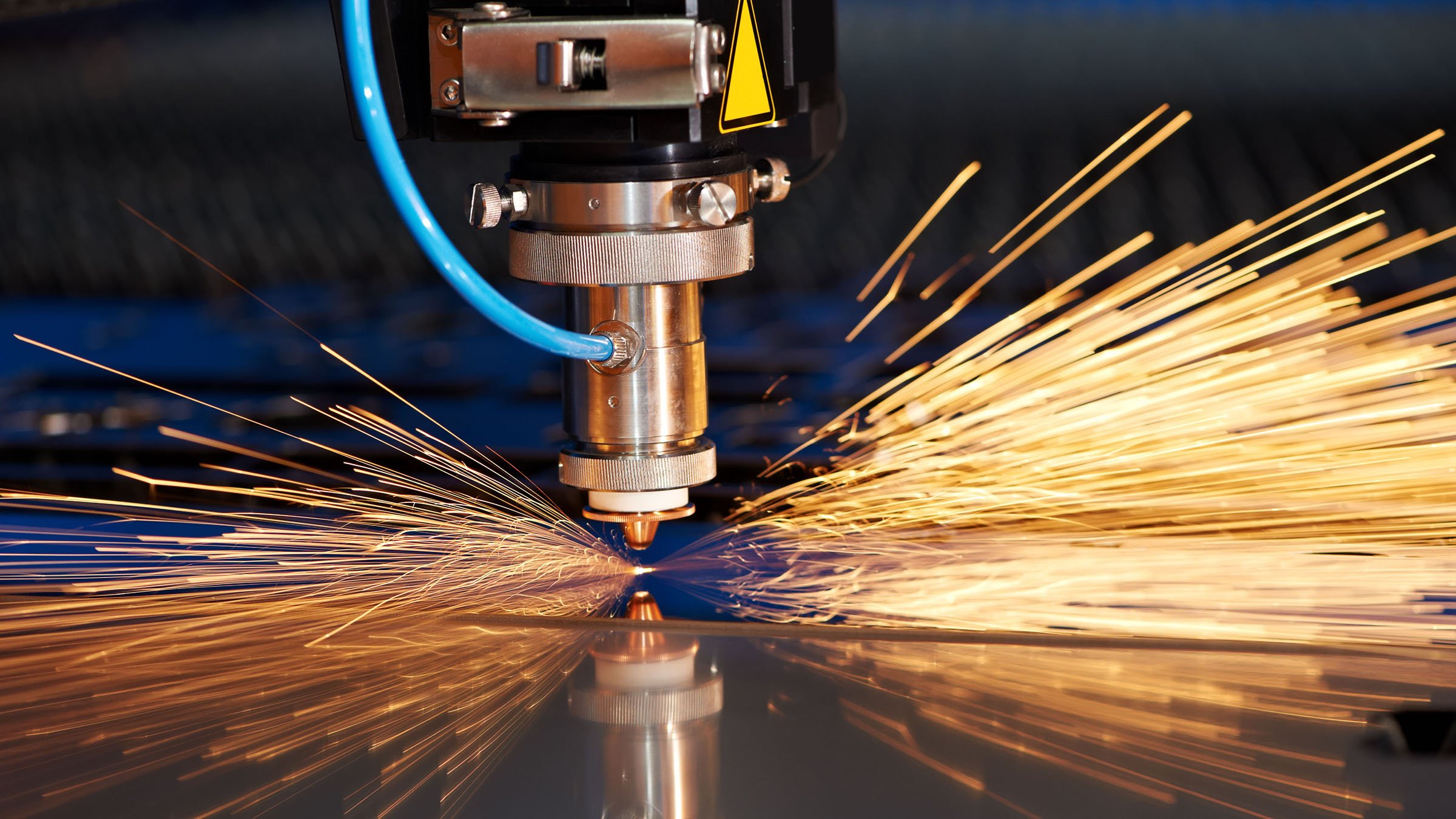 Industrial laser cutting on sheet metal with sparks. 