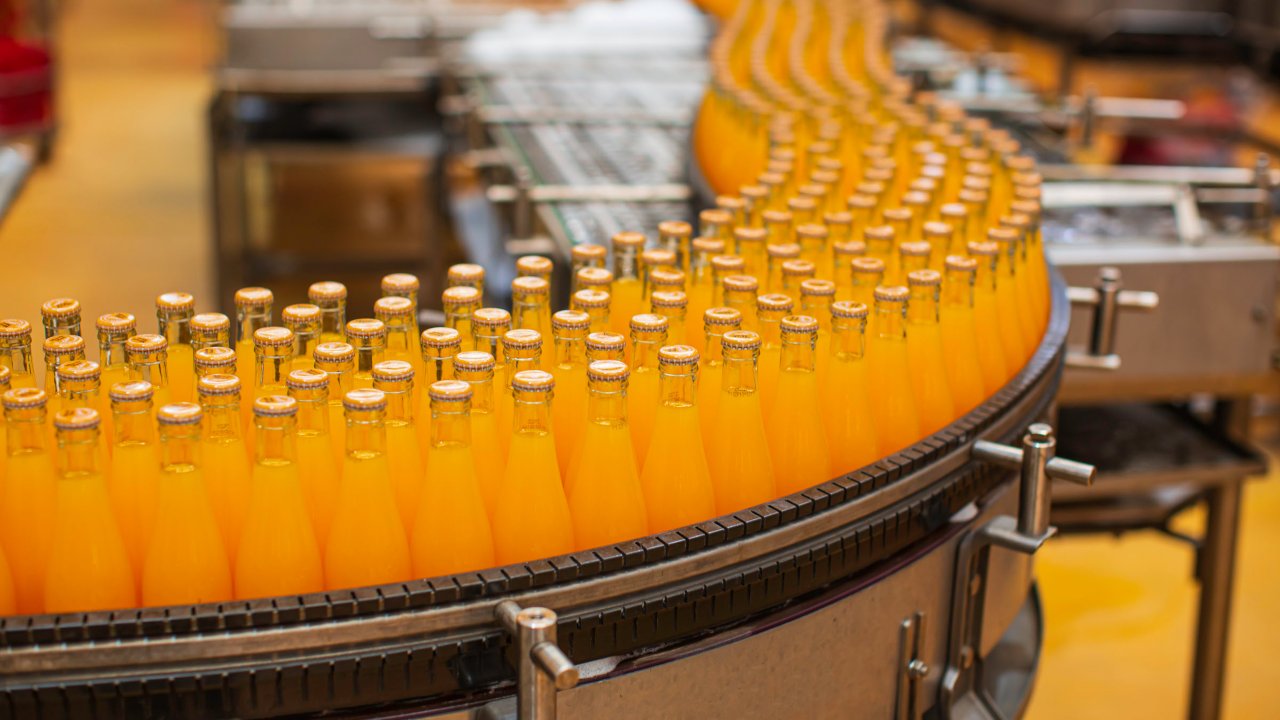 juice bottles move down conveyor belt food and beverage