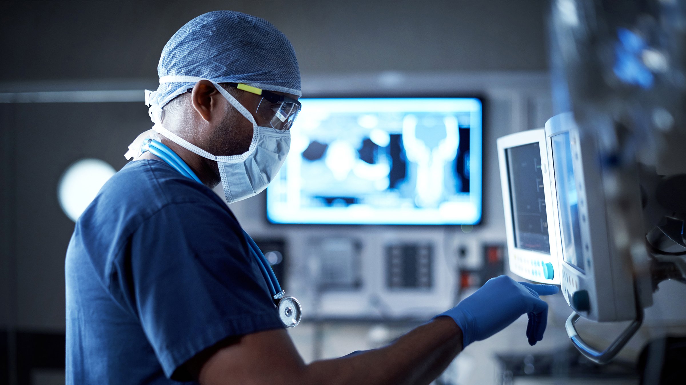 Male surgeon looking at software screen in hospital room
