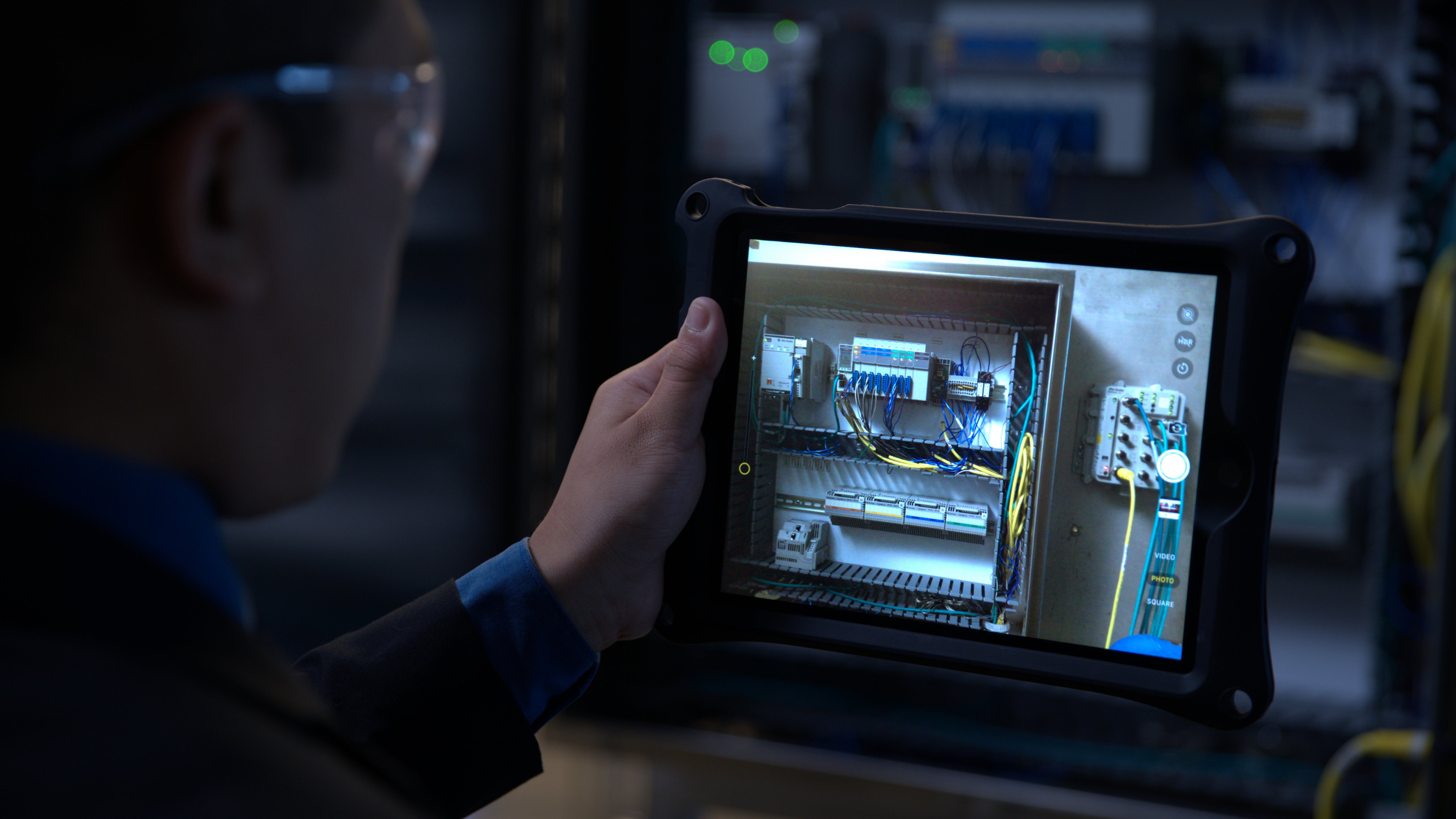 Man holding tablet looking at wiring