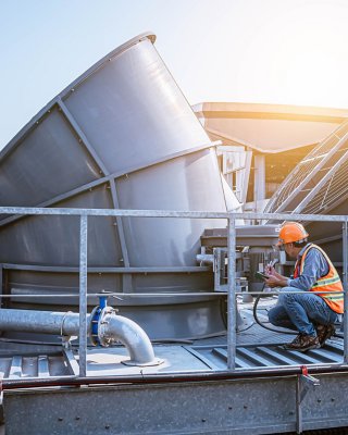 A engineer under checking the industry cooling tower air conditioner is water cooling tower air chiller HVAC of large industrial building to control air system